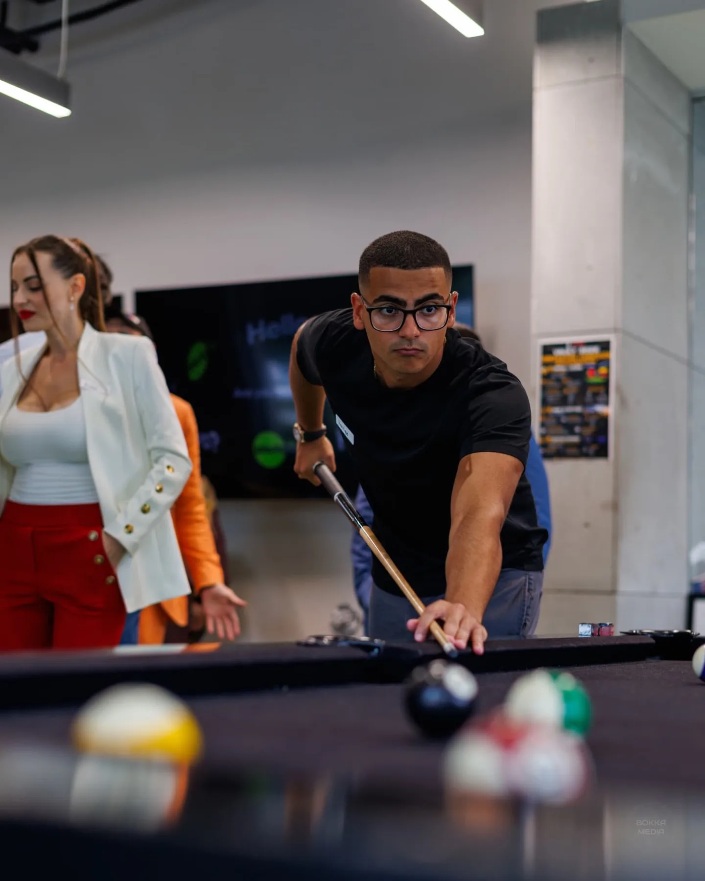 Guests in business attire playing pool inside the Valuetainment lounge