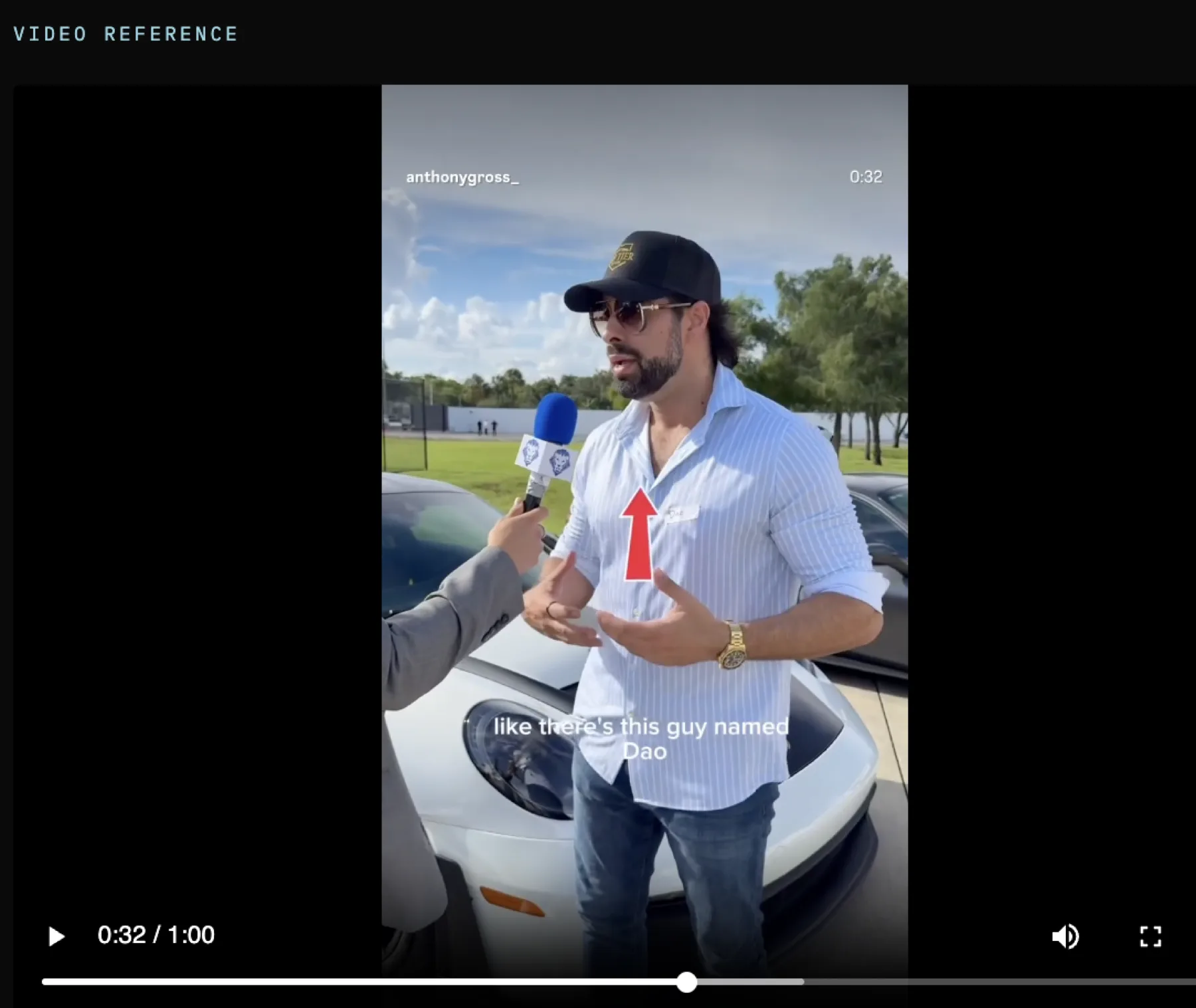 Dao on the tarmac with a microphone in hand, the cars and hangar behind him