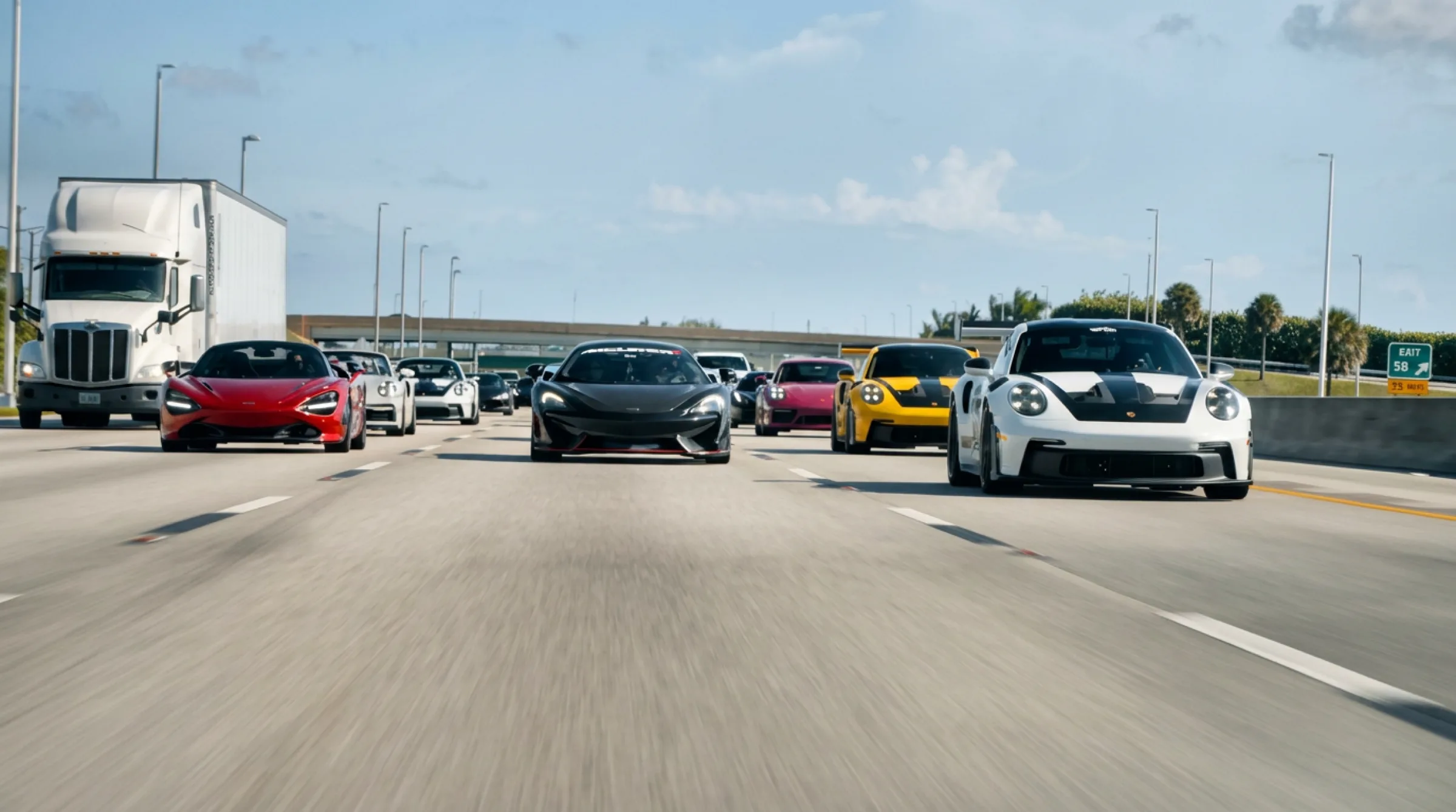 The TTMC convoy spanning four highway lanes in Miami sunlight