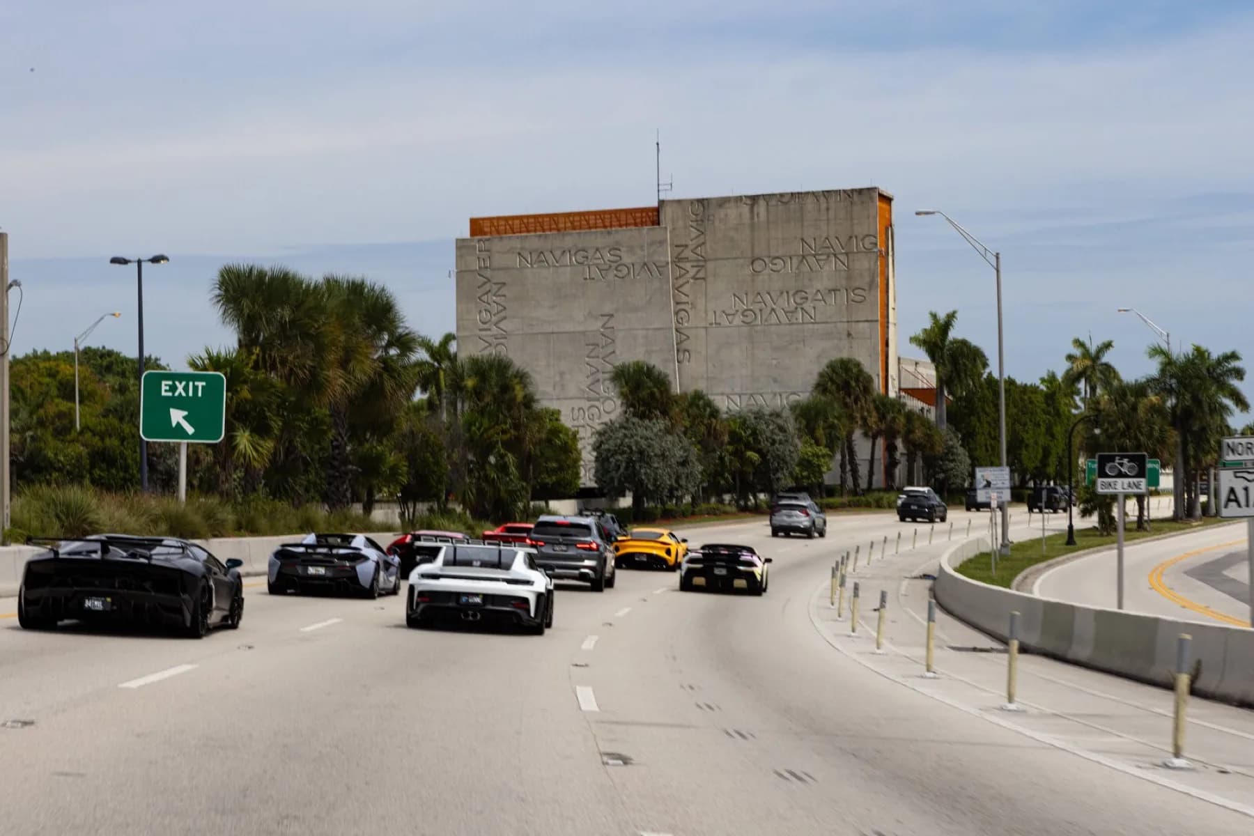 The convoy exiting the highway on a ramp toward Coconut Grove.